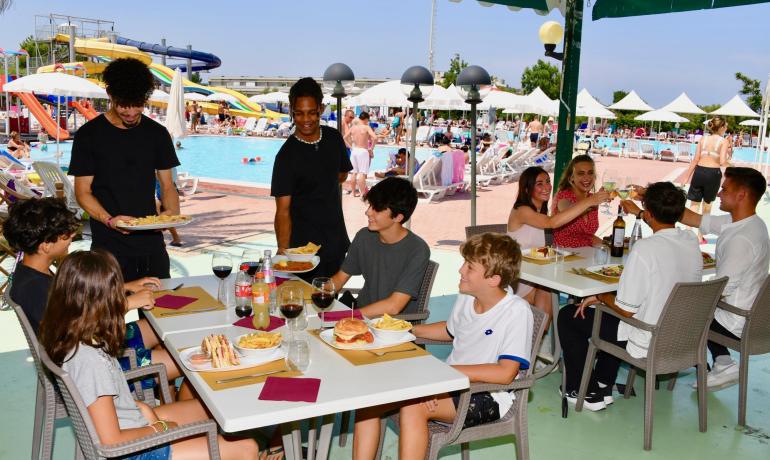 Menschen essen am Pool in einem Wasserpark.