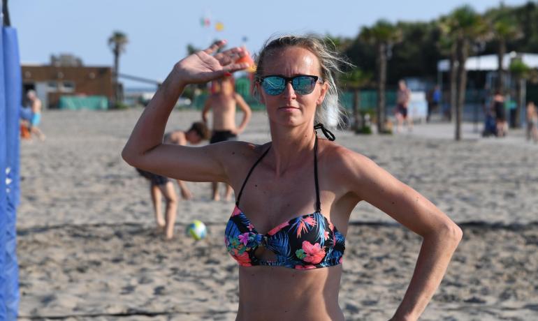 Frau im Bikini am Strand, reflektierende Sonnenbrille.