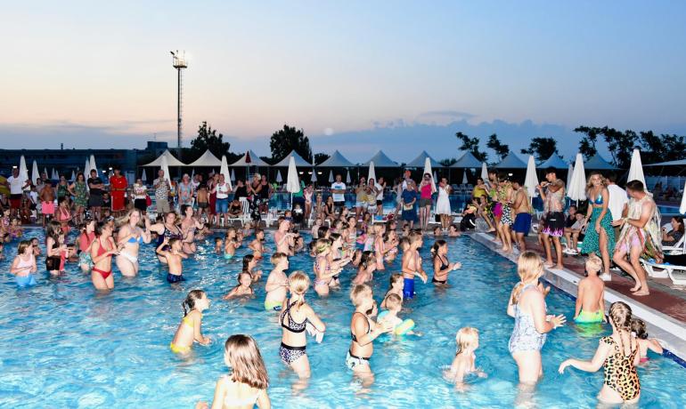 Poolparty mit vielen Menschen, die tanzen und Spaß haben.